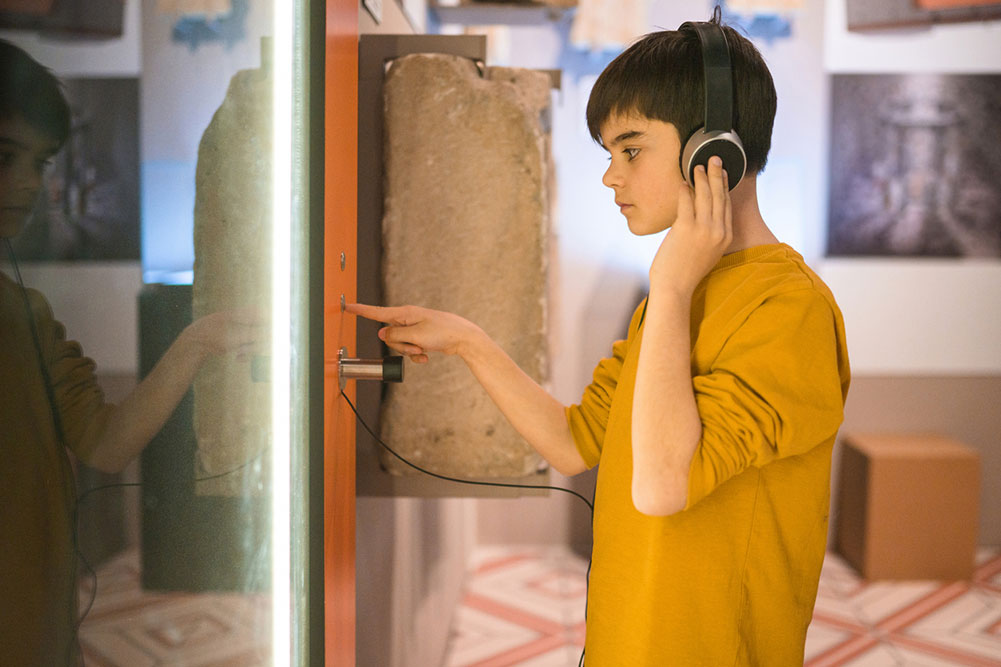 boy wearing headphones in a museum listening to information